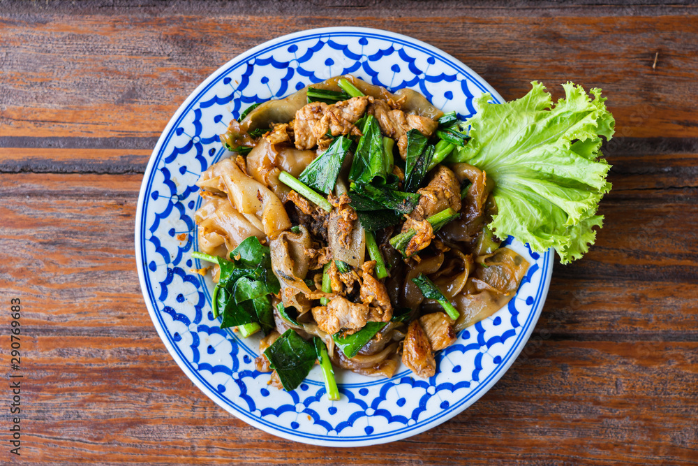 Fried Noodle in Soy Sauce in beautiful dish on wooden table, special Thai food in Thailand Fried Noodle in Soy Sauce in beautiful dish on wooden table, special Thai food in Thailand