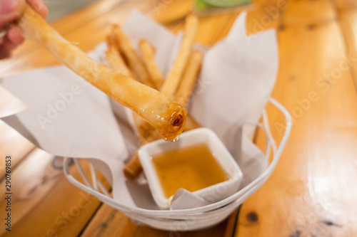Fried spring roll with shrimp and dipping sauce on wooden table. Snack food.