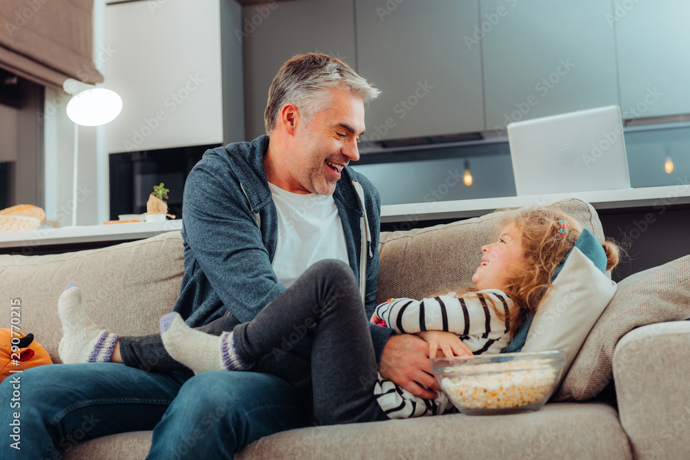 Positive delighted girl playing with her father