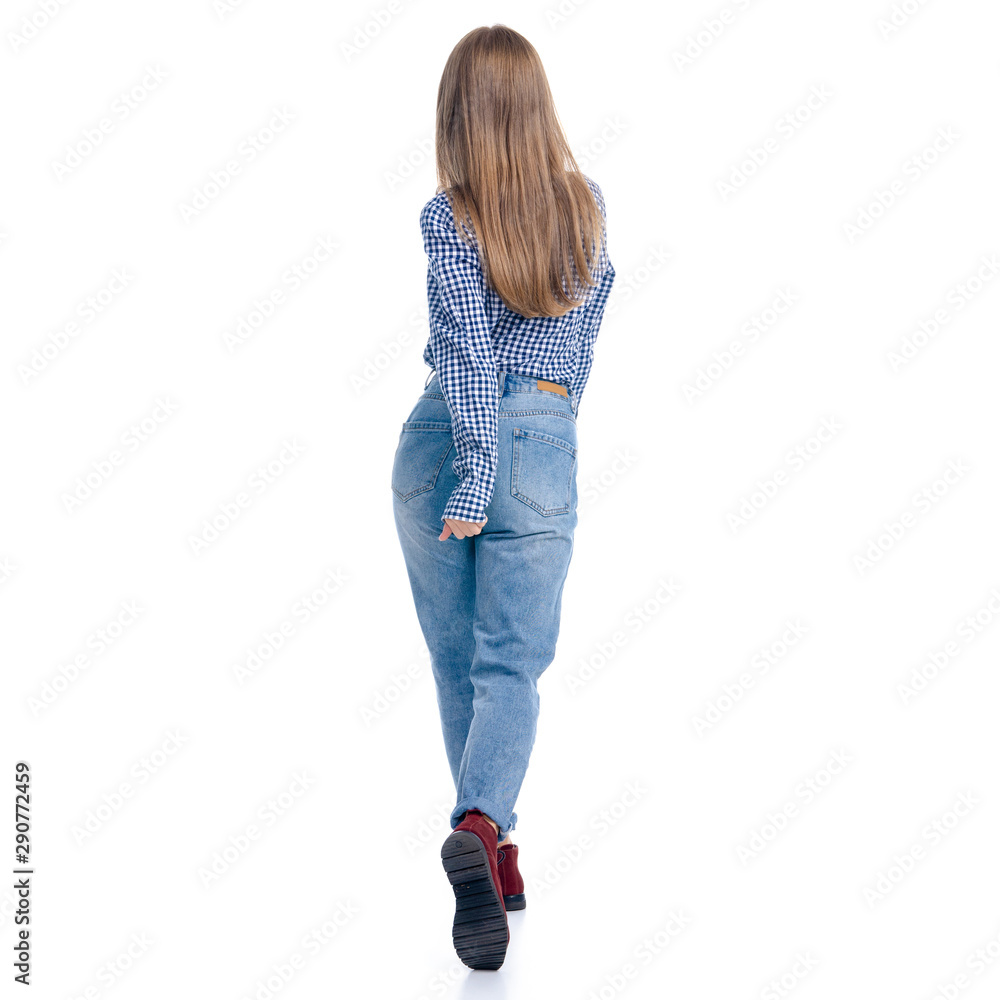 Woman in jeans and blue shirt smiling walking goes on white background isolation, rear view Woman in jeans and blue shirt smiling walking goes on white background isolation, rear view