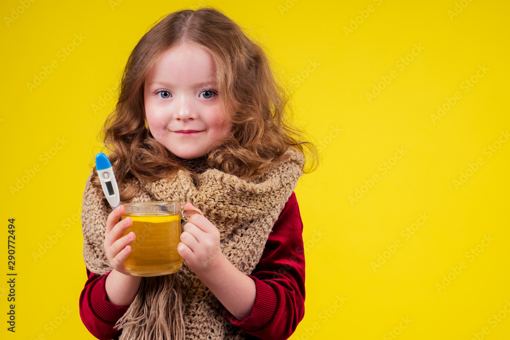sick illness little blonge girl wearing knitted scarf and drinking hot tea cup with lemon and ginger in studio yellow background sick illness little blonge girl wearing knitted scarf and drinking hot tea cup with lemon and ginger in studio yellow background