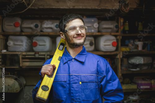 Portrait of a happy man working with a measuring device in his workshop.