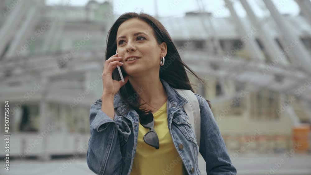 young woman walking and talking on smartphone young woman walking and talking on smartphone