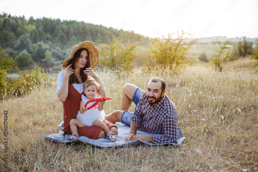 Beautiful family spending time on a field at sunset. Beautiful family spending time on a field at sunset.