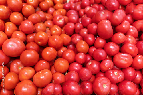 Close-up view of fresh juice tomatoes, background photography. supermarket counter, red and pink