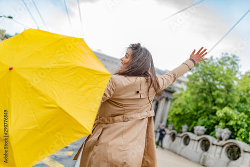 Woman with umbrella catching taxi. Hello taxi. Hailing a Taxi. Young girl with umbrella trying to stop a cab. Woman calling a taxi on a rainy day.