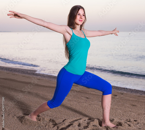 Smiling young woman in blue T-shirt is doing excercises on endurance