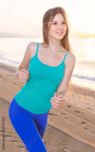 Smiling adult woman in blue T-shirt is jogging