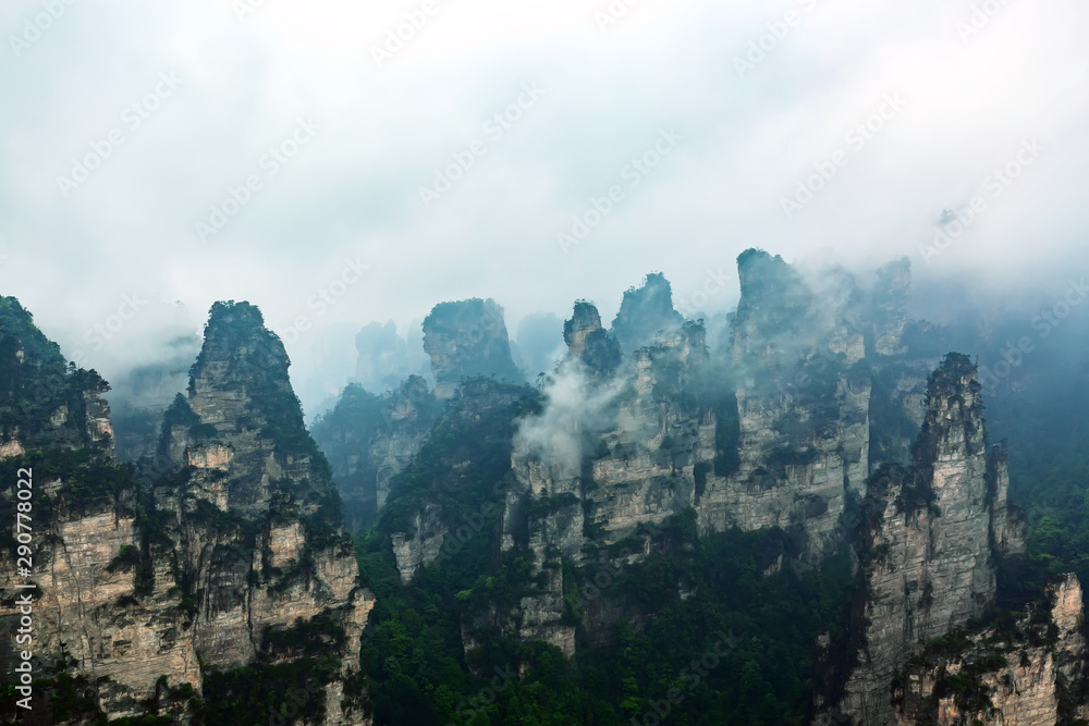 Zhangjiajie National park. Famous tourist attraction in Wulingyuan, Hunan, China. Amazing natural landscape with stone pillars quartz mountains in fog and clouds. Vintage styled image