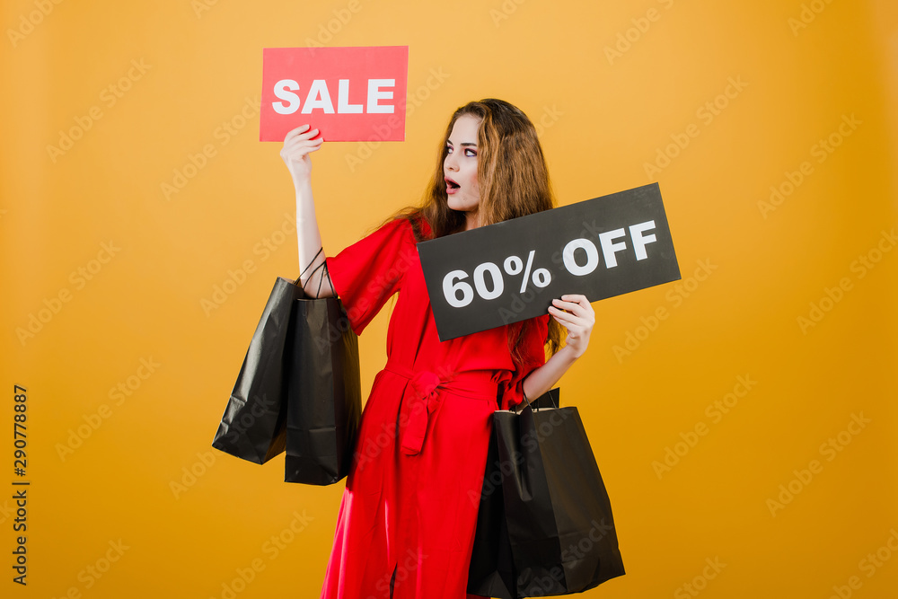 surprised woman has sale 60% off sign with paper shopping bags isolated over yellow surprised woman has sale 60% off sign with paper shopping bags isolated over yellow
