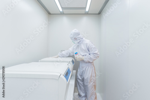 A scientist in sterile coverall gown using Cleaning tool for cleaning laboratory. Cleanroom facility.