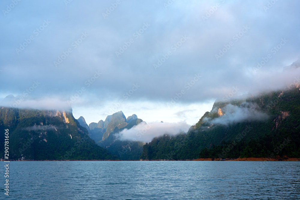 Clouds and mist over green limestone mountain in morning light Clouds and mist over green limestone mountain in morning light