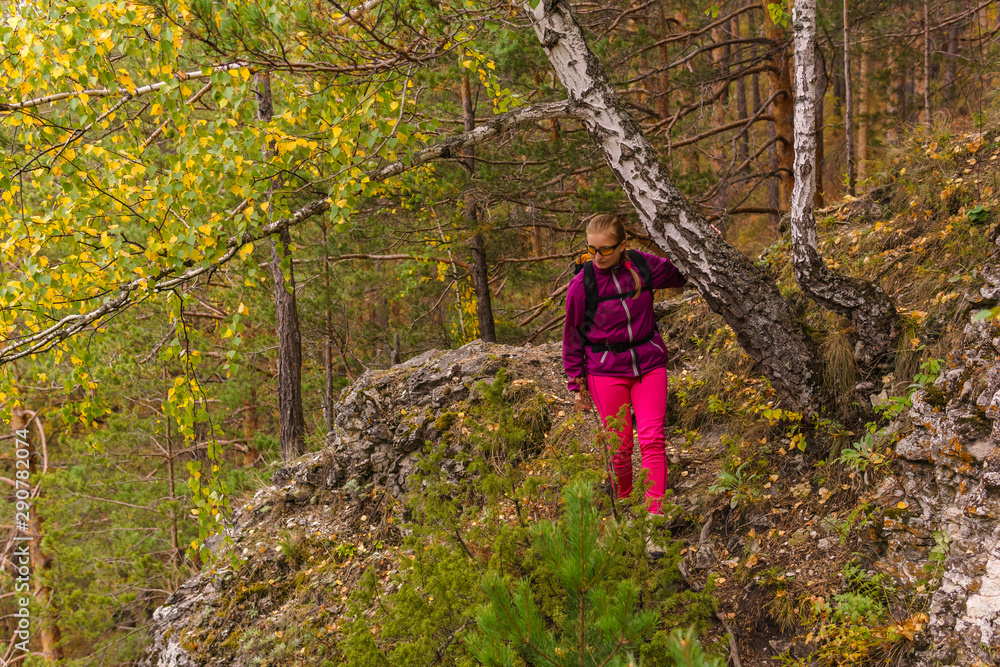 female hiker trekking in the autumn forest