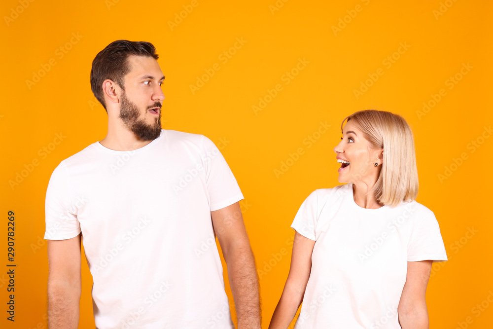 Young beautiful hipster couple having fun posing over isolated yellow background. Portrait of tall man with groomed beard and his short attractive blonde girlfriend. Copy space, close up. Young beautiful hipster couple having fun posing over isolated yellow background. Portrait of tall man with groomed beard and his short attractive blonde girlfriend. Copy space, close up.