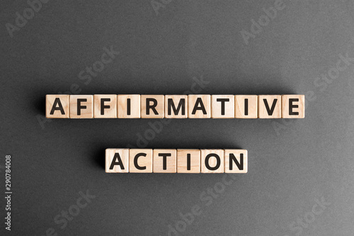Affirmative Action - word from wooden blocks with letters, gives preference to group of people affirmative action concept,  top view on grey background photo