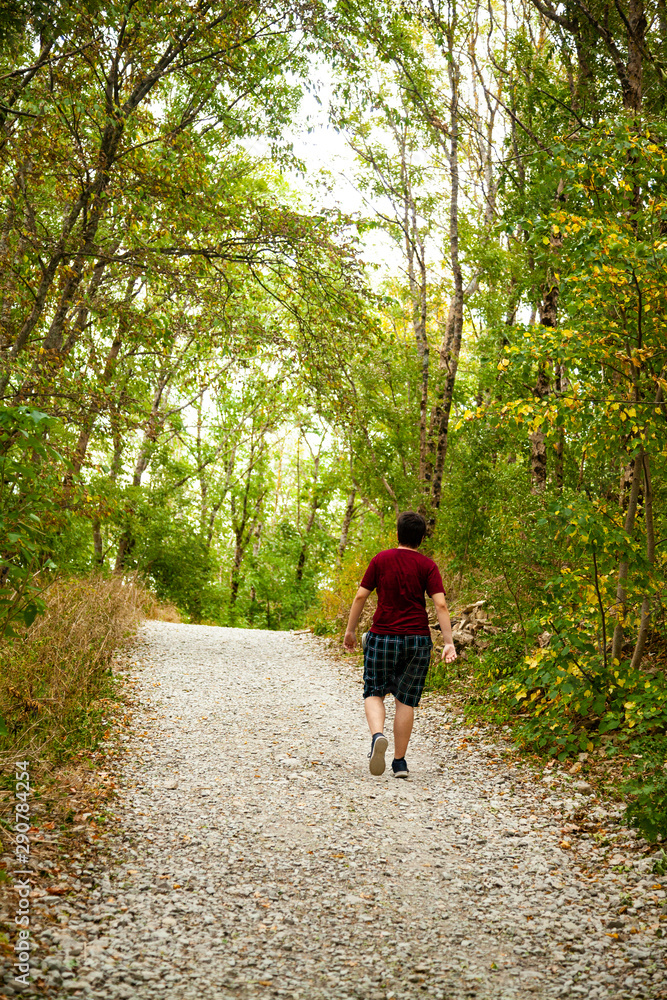 Young man walks along a path in a mountain forest. Young man walks along a path in a mountain forest.