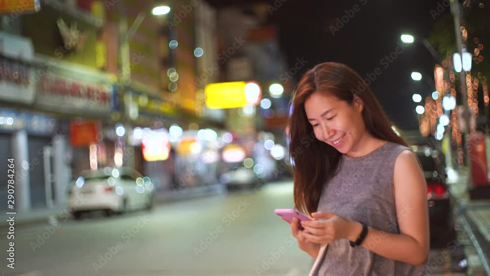 Young asian woman using smartphone in street side at night, lifestyle concept Young asian woman using smartphone in street side at night, lifestyle concept