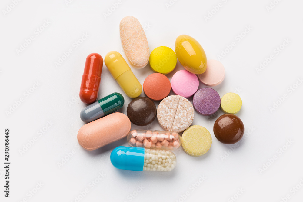 Assorted pharmaceutical medicine pills, tablets and capsules.Heap of assorted various medicine tablets and pills different colors on white background. Top view.Copy space Assorted pharmaceutical medicine pills, tablets and capsules.Heap of assorted various medicine tablets and pills different colors on white background. Top view.Copy space