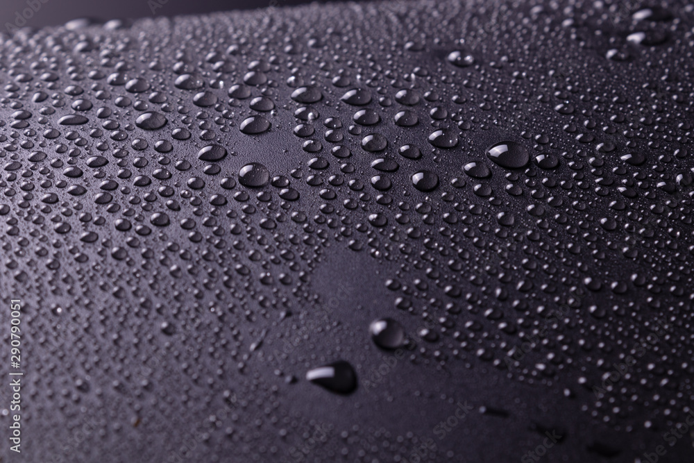 on a dark gray background in a studio with white lighting and unevenly sprayed drops of water and white highlights.