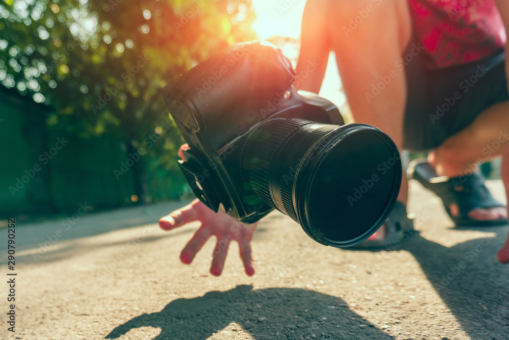 The photographer dropped the camera and catches it with his hands, the  camera falls on the asphalt. Stock Photo | Adobe Stock