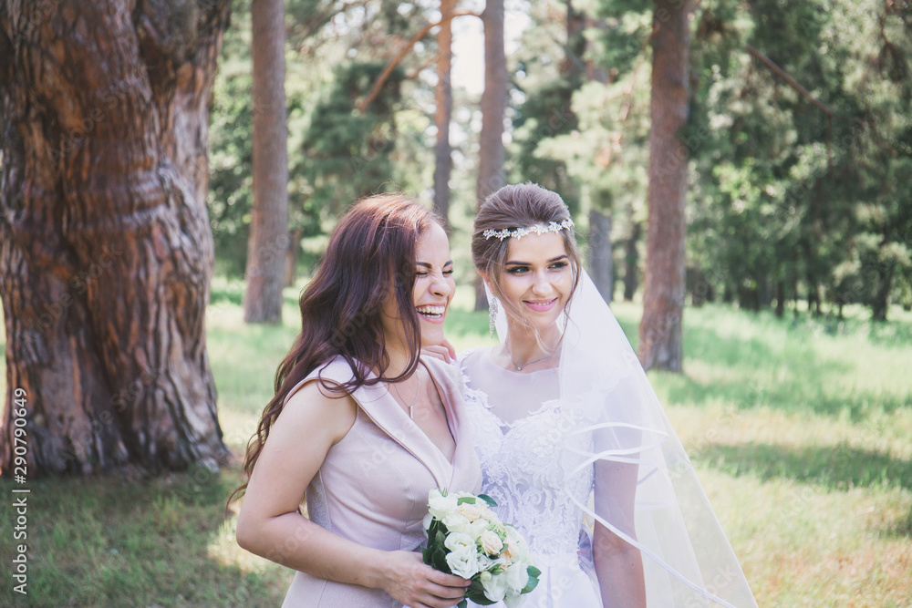 Bride and bridesmaid in the park, close-up Bride and bridesmaid in the park, close-up