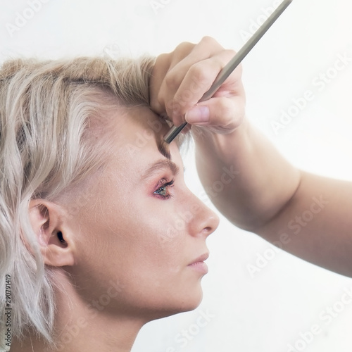 Young blonde woman model during makeup before photo session
