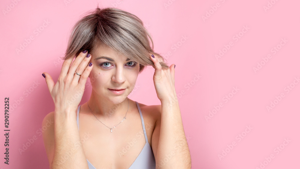 Portrait of young romantic woman with tender smile wearing casual outfit in pastel colors over pink background Portrait of young romantic woman with tender smile wearing casual outfit in pastel colors over pink background