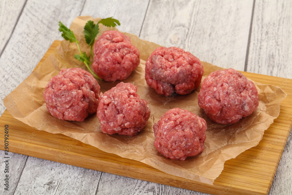 Raw meatball over wooden background Raw meatball over wooden background