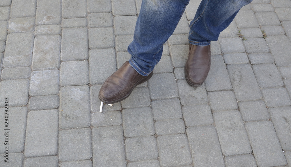 Smoking harms the human body. Male foot trample a cigarette. Smoking harms the human body. Male foot trample a cigarette.