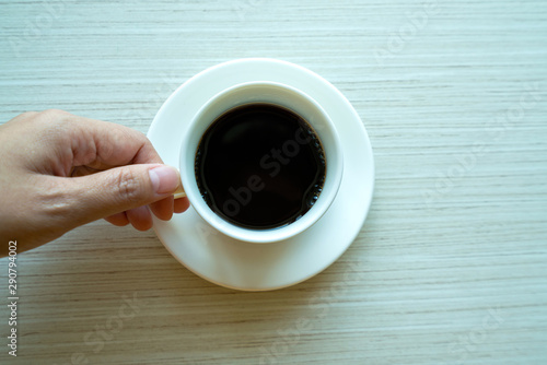 hands holding back coffee on wooden table background