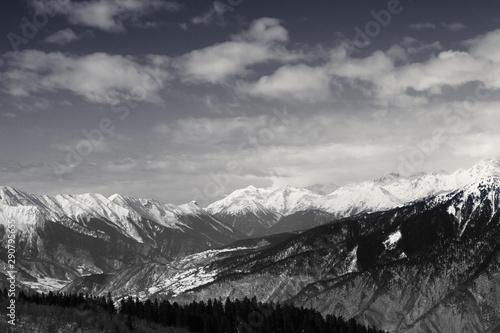 Snowy mountains and sky with clouds at winter sun day © BSANI