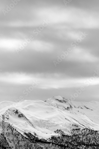Snowy mountains and gray cloudy sky at winter