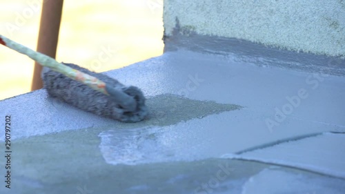 Hand Holding Paint Roller And Painting 