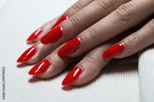applying red gel nail polish on women s nails