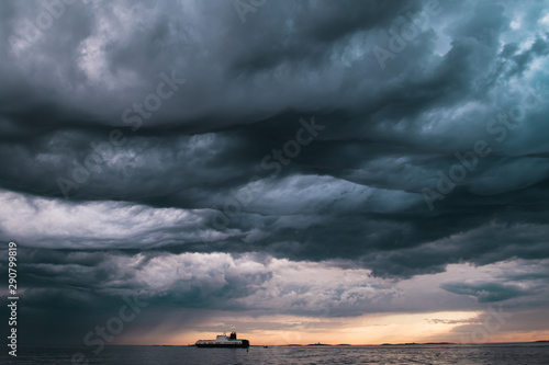 A cargo ship underneath stormy clouds