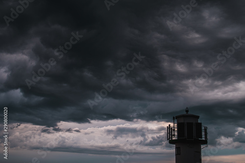A lighthouse infront of stormy clouds
