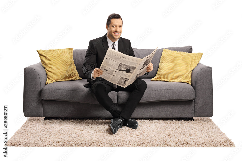 Businessman reading a newspaper ona sofa and smiling at the camera Businessman reading a newspaper ona sofa and smiling at the camera