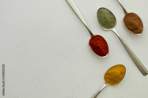 Various colorful spices arranged on spoons