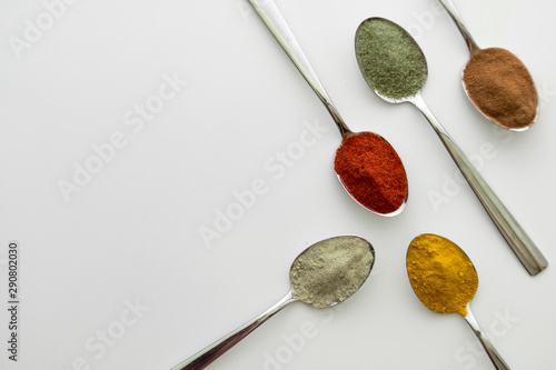 Various colorful spices arranged on spoons