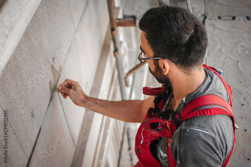 Man worker standing on scaffolding and restore old building facade