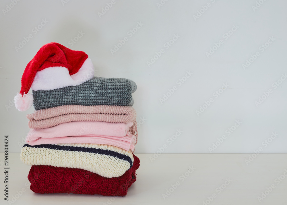 Pile sweater with Santa hat on table Pile sweater with Santa hat on table