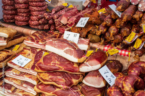 Assortment of delicious smoked spicy sausages, bacon and salami in a folk arts and crafts fair market, street food