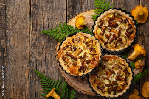 savory tartlets with chanterelle and onion on wooden background