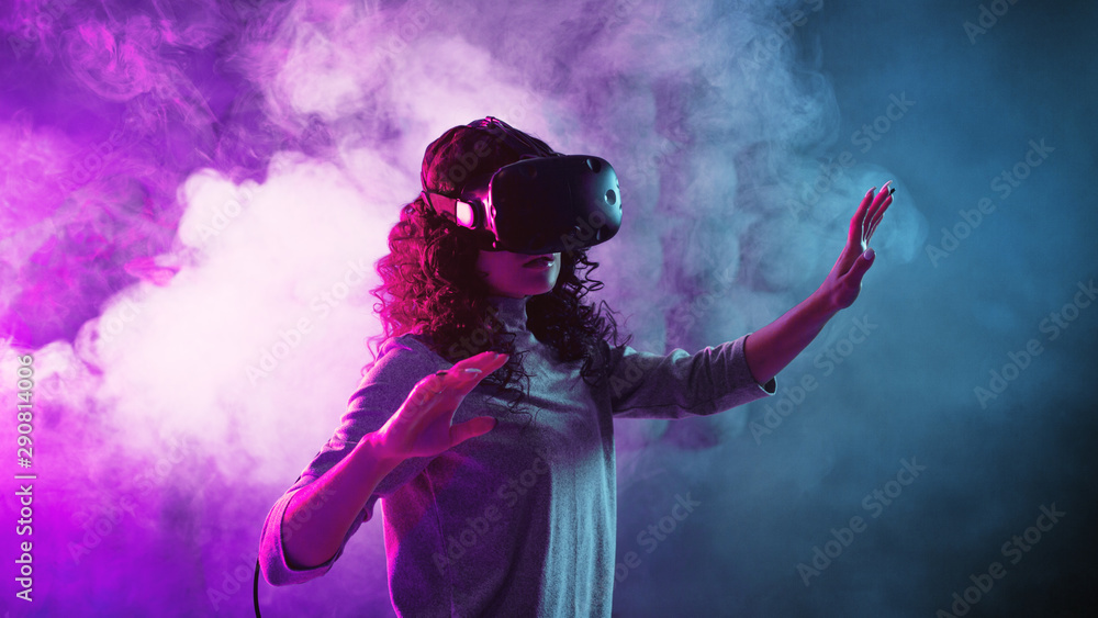 Virtual reality game. A girl in a VR helmet plays a game or explores the environment. Virtual reality game. A girl in a VR helmet plays a game or explores the environment.