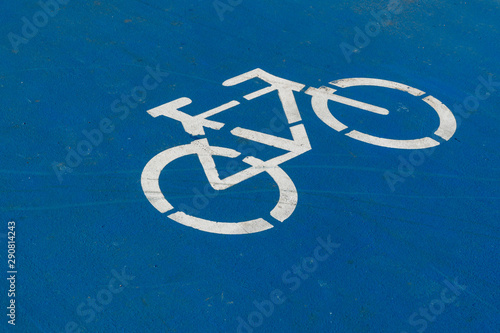 Blue bicycle lane sign on road.