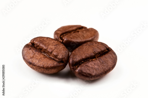 three coffee beans on a white isolated background close-up