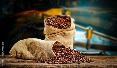 Coffee beans in jute sacks with blurrred coffee machine view