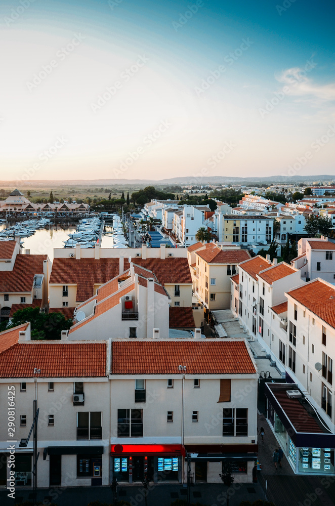 High perspective view of sunset at Vilamoura Marina, Algarve, Portugal with busy nightlife around the Marina full of shops and restaurants