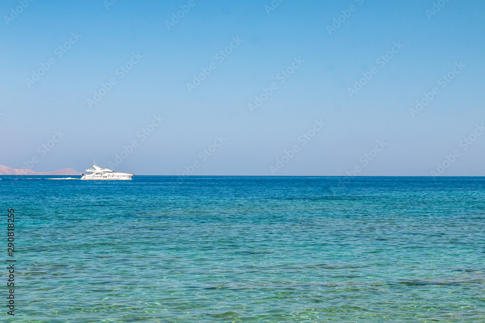 Boat sailing far at the open sea. Yacht at sea. Luxury summer adventure, active vacation in Mediterranean sea.