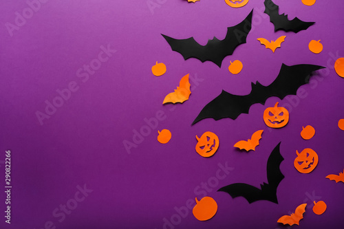 Halloween background with paper pumpkins  Jack O Lantern  black  orange paper bats flying over purple background  . Copy space. Halloween and decoration concept.